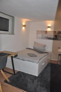 Cette petite chambre comprend un lit et un bureau. dans l'établissement Stadtnaher heller Souterrain, à Oldenbourg