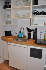- une cuisine avec un évier et un comptoir dans l'établissement Stadtnaher heller Souterrain, à Oldenbourg
