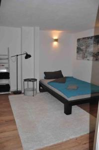 - une chambre avec un lit, une lampe et un tapis dans l'établissement Stadtnaher heller Souterrain, à Oldenbourg