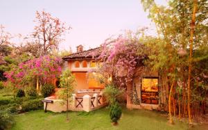 una casa con un jardín con flores rosas en Tuli Tiger Resort, en Dhanwār