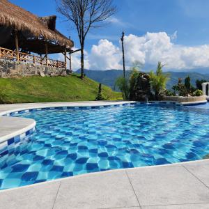 une grande piscine avec une hacienda dans l'établissement Villeta Casa de Campo caracoli spa, à Villeta