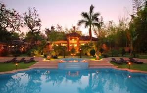 Dhanwār图里老虎度假村的一栋房子前面有游泳池