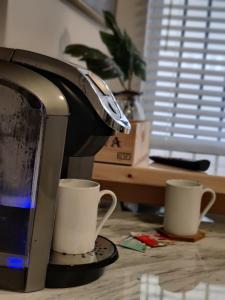 un monitor de ordenador y dos tazas en una mesa en Bonito departamento remodelado tranquilo y centrico, en Ciudad Juárez