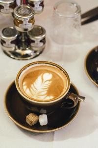 una taza de café en un plato en una mesa en Laburnum Guest House at Bistro En Glaze, en Wylam