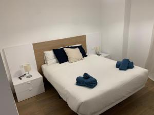 a bedroom with a large bed with blue towels on it at Apartamentos Central B in Algeciras