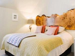 a bedroom with a large bed with a wooden headboard at Reidochie Stables luxury haven overlooking garden in Blairgowrie