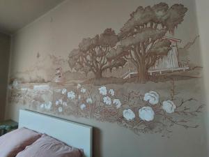 un murale sulla parete di una camera da letto con fiori bianchi di La Chicca a Annicco