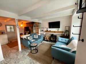 a living room with two blue couches and a fireplace at 3 Peters Terrace in Truro