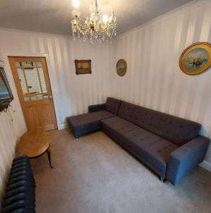 Lovely 1 Bed house in Largs, North Ayrshire في لارغس: غرفة معيشة مع أريكة وطاولة