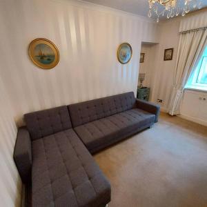 Lovely 1 Bed house in Largs, North Ayrshire في لارغس: غرفة معيشة مع أريكة في الزاوية