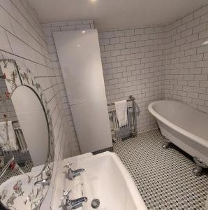 Lovely 1 Bed house in Largs, North Ayrshire في لارغس: حمام مع حوض ومغسلة وحوض استحمام