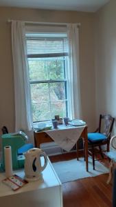 sala de estar con mesa y ventana en Sea Birds Cottage, en Victoria