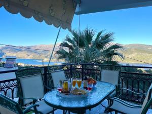 een tafel met een mand met eten en drinken op een balkon bij Villa Serenity Spilia 1st floor in Argostoli