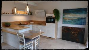 - une cuisine avec un comptoir, un évier et une cuisinière dans l'établissement Au gré des marées, à Roscoff