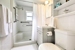 a white bathroom with a toilet and a shower at Cozy OBrien Home with Fire Pit and Patio Near Rivers! in Branford +16 photos