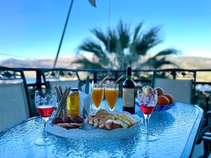 un tavolo con un piatto di cibo e bicchieri di vino di Villa Serenity Spilia 1st floor ad Argostoli