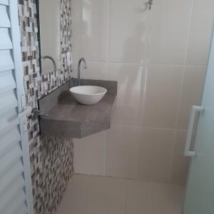 a bathroom with a bowl sink on a wall at Pousada Aconchego in Ilha Comprida