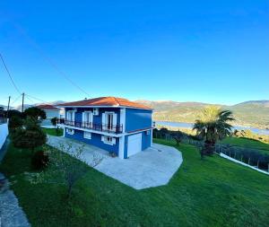 una casa azul con una palmera en un patio en Villa Serenity Spilia 1st floor, en Argostoli