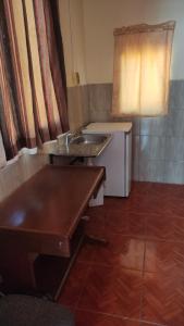 una pequeña cocina con fregadero y mesa en Concordia - Hospedaje, en Cochabamba