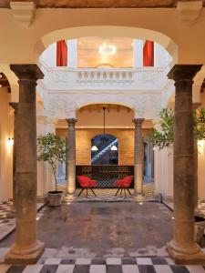 a lobby with two red chairs and a ceiling at Carlota Sustainable Design Hotel in Quito