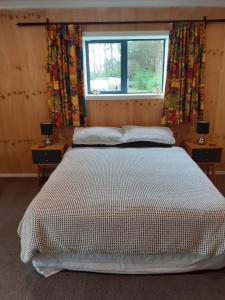 um quarto com uma cama grande e 2 mesas de cabeceira em Pin Oaks em Whanganui