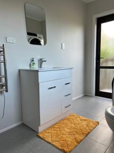 bagno con lavandino e specchio a parete di Yucca Home ad Auckland