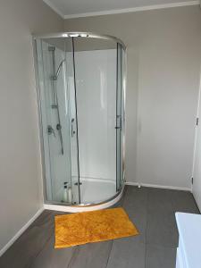 a bathroom with a shower with a yellow rug at Yucca Home in Auckland