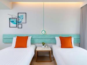 Novotel Rayong Rim Pae Resort客房内的一张或多张床位