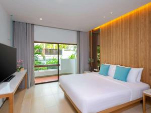 港生Novotel Rayong Rim Pae Resort的卧室里有一张白色的大床和一台电视