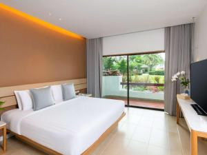 Novotel Rayong Rim Pae Resort的电视和/或娱乐中心