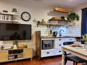 a kitchen with a table and a clock on the wall at Frostwood House in Mount Barker