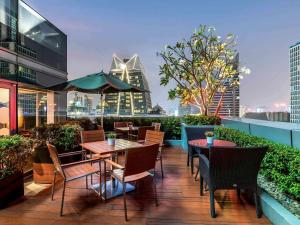 a patio with tables and chairs on top of a building at Novotel Bangkok Ploenchit Sukhumvit in Bangkok