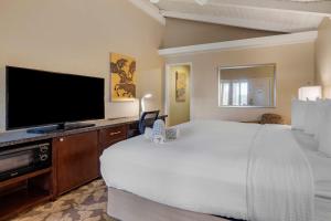 a hotel room with a large bed and a flat screen tv at Best Western PLUS Island Palms Hotel & Marina in San Diego