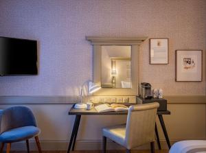 a room with a desk with a mirror and a chair at Hôtel Littéraire Gustave Flaubert, BW Signature Collection in Rouen