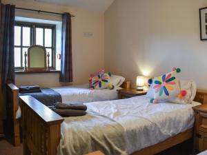 a bedroom with two beds and a mirror at Mount Cottage-uk42230 in Low Borrowbridge