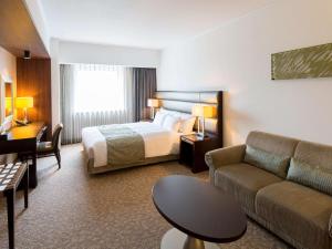 札幌市にあるイビス スタイルズ 札幌のベッドとソファ付きのホテルルーム