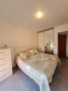 a bedroom with a bed and a dresser and a mirror at Resistencia City Apartment in Resistencia