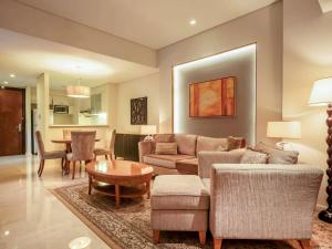 a living room with a couch and a table at Joy Nostalg Hotel and Suites Manila Managed by The Ascott Limited in Manila