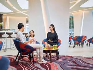 un grupo de personas sentadas en sillas en una habitación en Novotel Hanoi Thai Ha, en Hanói