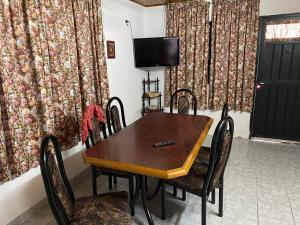 mesa de comedor con sillas y TV en Casa en Las Grutas en Las Grutas