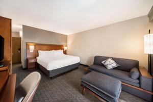 una habitación de hotel con una cama y un sofá en Sonesta Select San Jose Airport, en San José