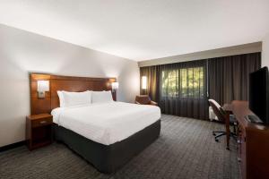 a hotel room with a bed and a television at Sonesta Select San Jose Airport in San Jose