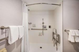 a bathroom with a shower with white towels and a toilet at Sonesta Select San Jose Airport in San Jose +34 photos