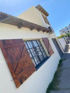 un edificio con puertas de madera en un lateral en Casa en Las Grutas en Las Grutas