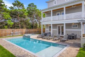 a swimming pool in front of a house at The Sand Emperor With Heated Pool And Game Room in Destin