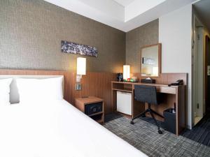 a hotel room with a bed and a desk at ibis Styles Tokyo Ginza in Tokyo