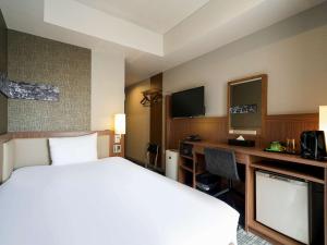 a hotel room with a large bed and a desk at ibis Styles Tokyo Ginza in Tokyo