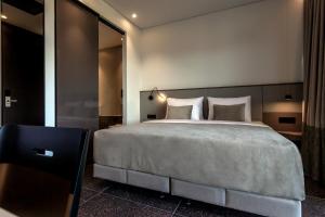 a bedroom with a large bed and a mirror at ACRO Upscale Residences in Kórinthos