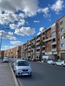 马拉喀什Appartement a loué pour les familles的停在街道边的有建筑物的汽车