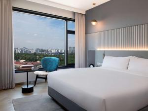 a bedroom with a bed and a desk and a large window at Mondrian Seoul Itaewon in Seoul